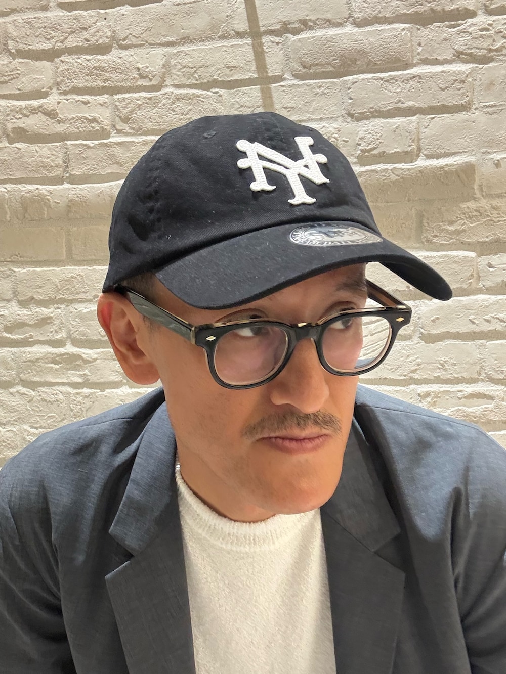 ブルー系のテーラードジャケット、ホワイト系のTシャツ/カットソー、ブラック系のデニムパンツを着用したメンズの秋コーディネートの4枚目の写真