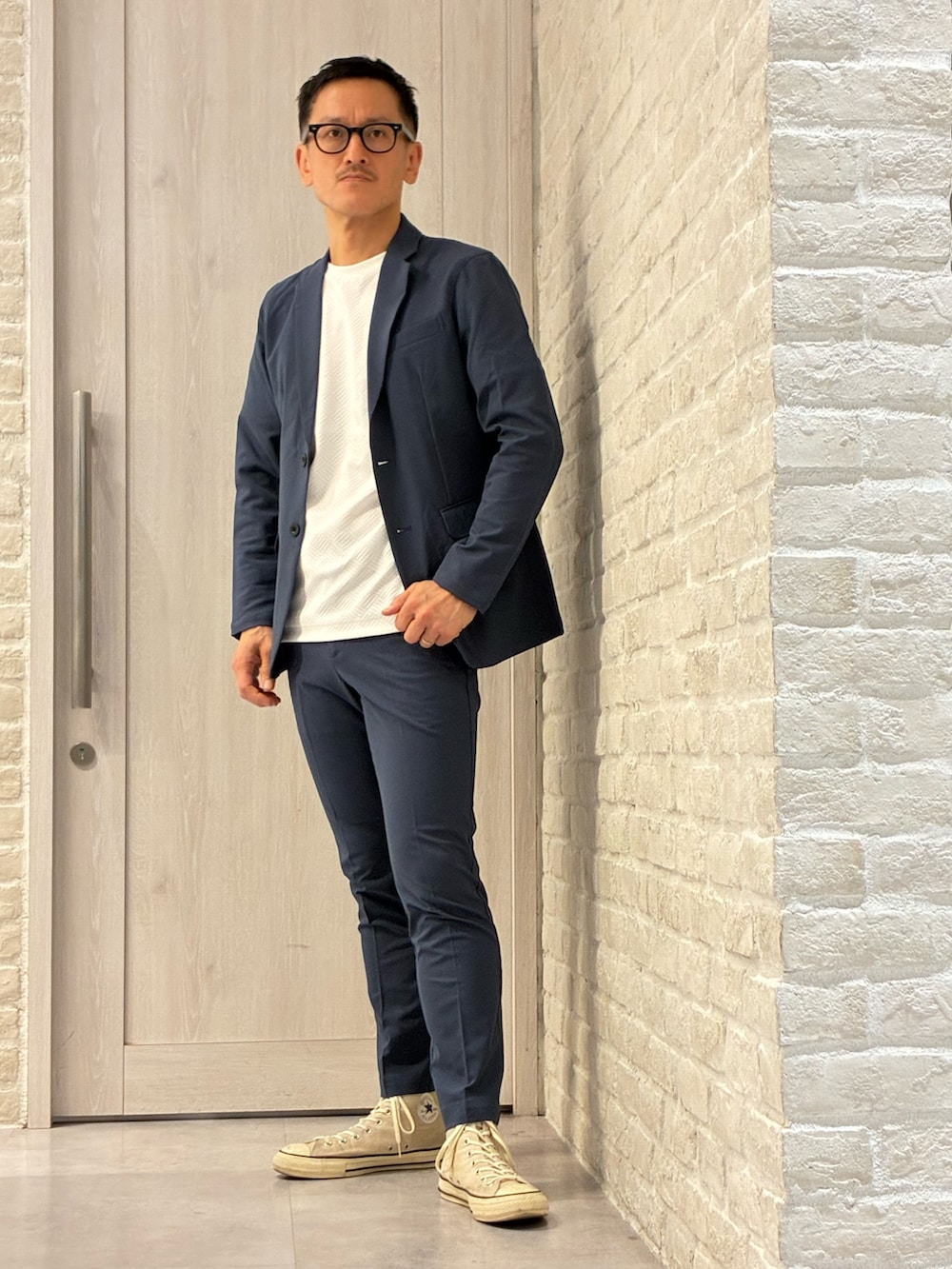 ブラック系のバックパック/リュック、ホワイト系のTシャツ/カットソー、ブルー系のテーラードジャケットを着用したメンズの春コーディネートの3枚目の写真