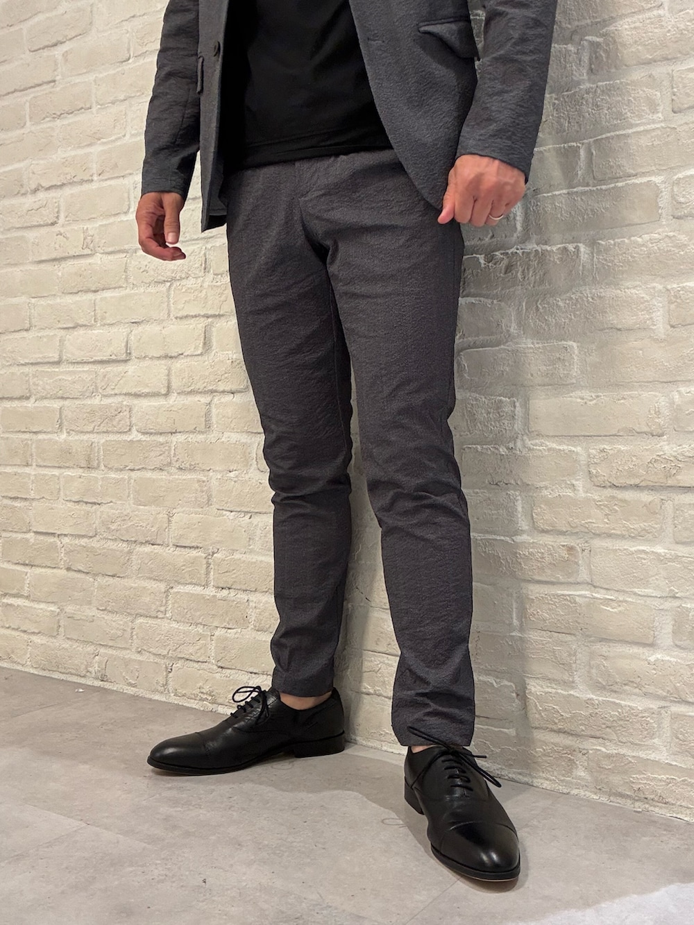 グレー系のセットアップ、グレー系のテーラードジャケット、ブラック系のTシャツ/カットソーを着用したメンズの夏コーディネートの4枚目の写真