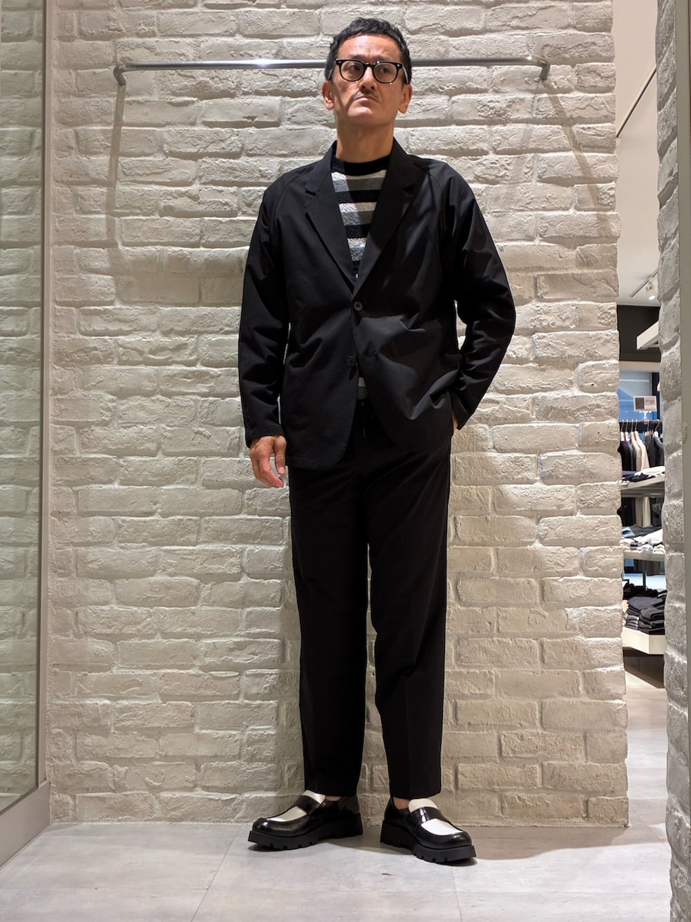 ブラック系のセットアップ、ブラック系のスラックス、ブラック系のTシャツ/カットソーを着用したメンズの夏コーディネートの5枚目の写真