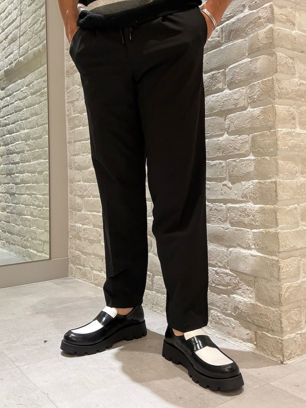 ブラック系のセットアップ、ブラック系のスラックス、ブラック系のTシャツ/カットソーを着用したメンズの夏コーディネートの3枚目の写真