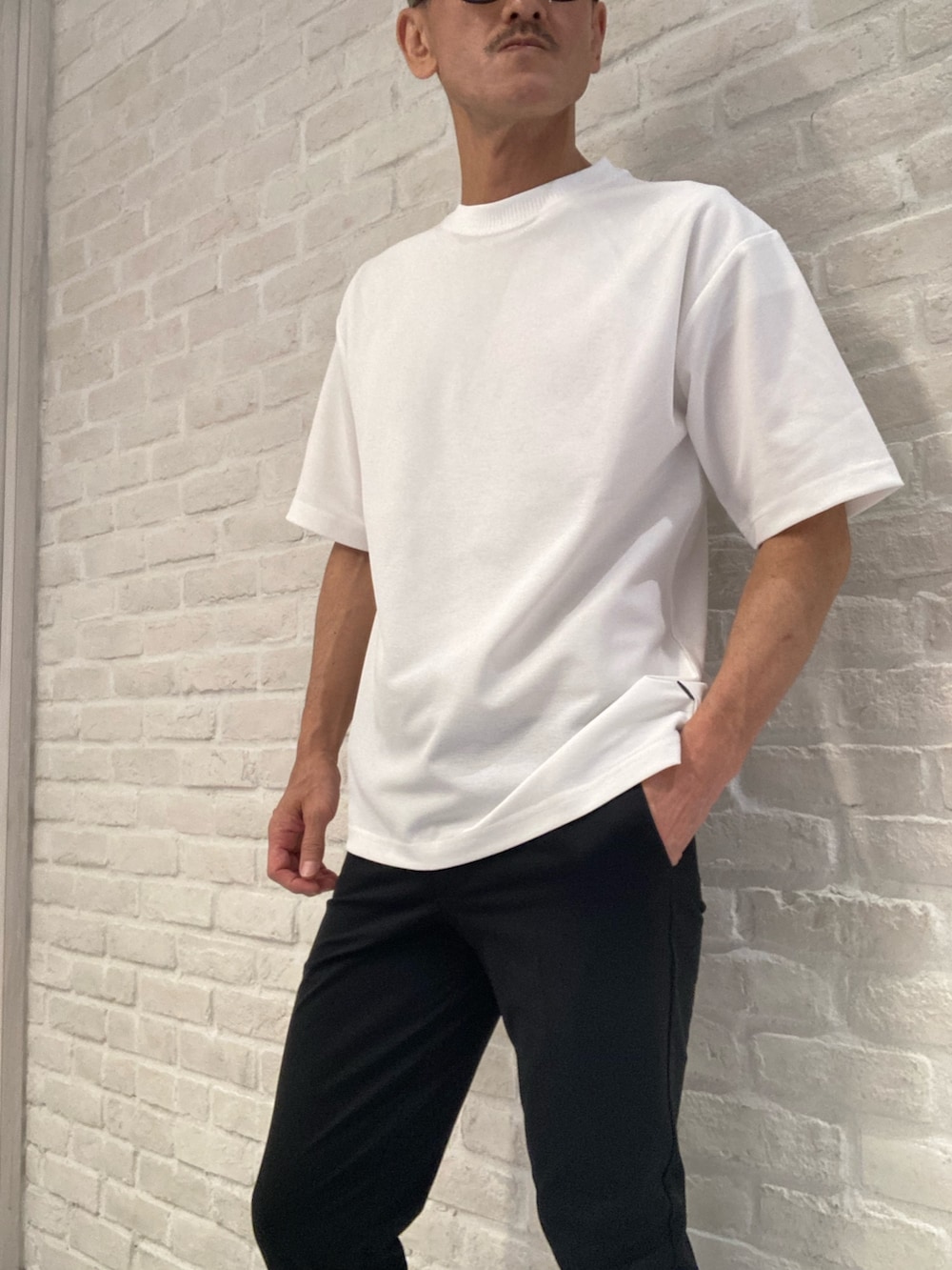 グレー系のブルゾン、ホワイト系のTシャツ/カットソー、ブラック系のスラックスを着用したメンズの夏コーディネートの3枚目の写真