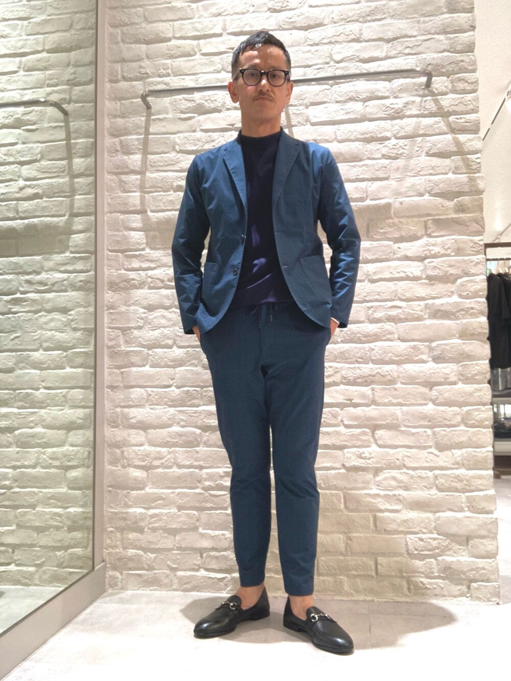 ブルー系のテーラードジャケット、ブルー系のスラックス、ブルー系のTシャツ/カットソーを着用したメンズの秋コーディネートの2枚目の写真