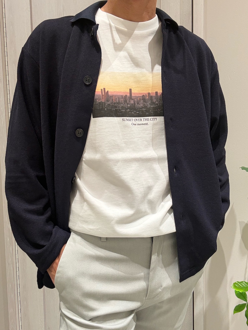 ブルー系のカーディガン/ボレロ、ホワイト系のTシャツ/カットソー、ベージュ系のスラックスを着用したメンズの秋コーディネートの5枚目の写真