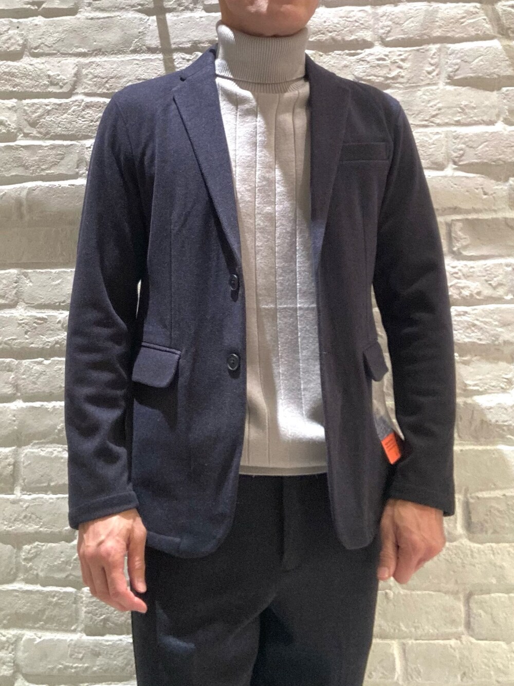 ブルー系のセットアップ、ブルー系のテーラードジャケット、ベージュ系のニット/セーターを着用したメンズの冬コーディネートの2枚目の写真