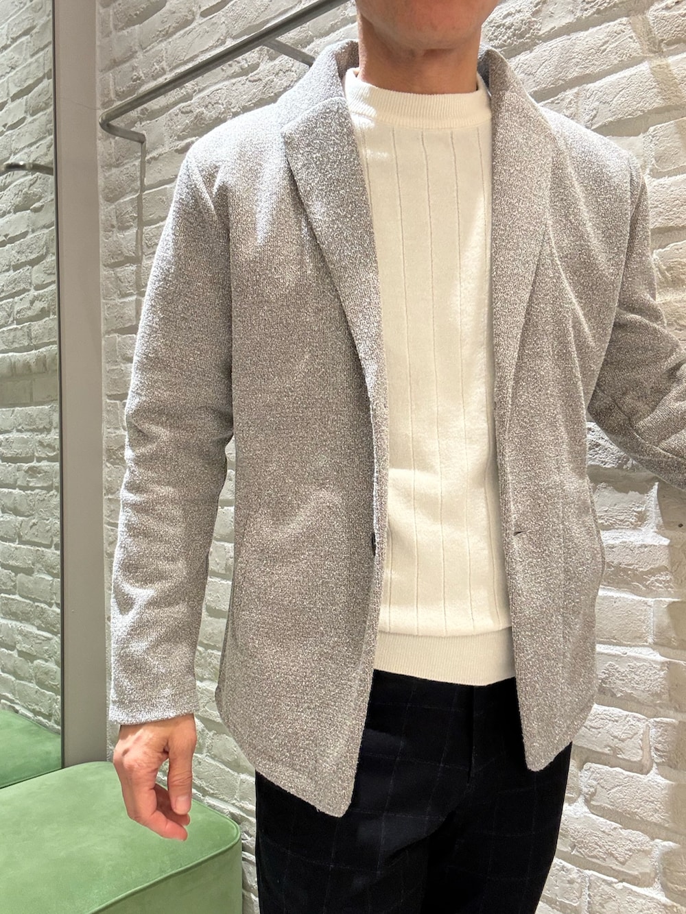 ブルー系のステンカラーコート、ブラウン系のブルゾン、ホワイト系のニット/セーターを着用したメンズの春コーディネートの5枚目の写真