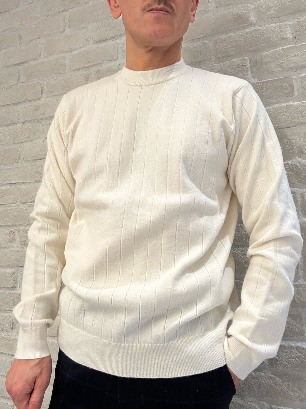 ブルー系のテーラードジャケット、ホワイト系のニット/セーター、ブルー系のスラックスを着用したメンズの冬コーディネートの4枚目の写真