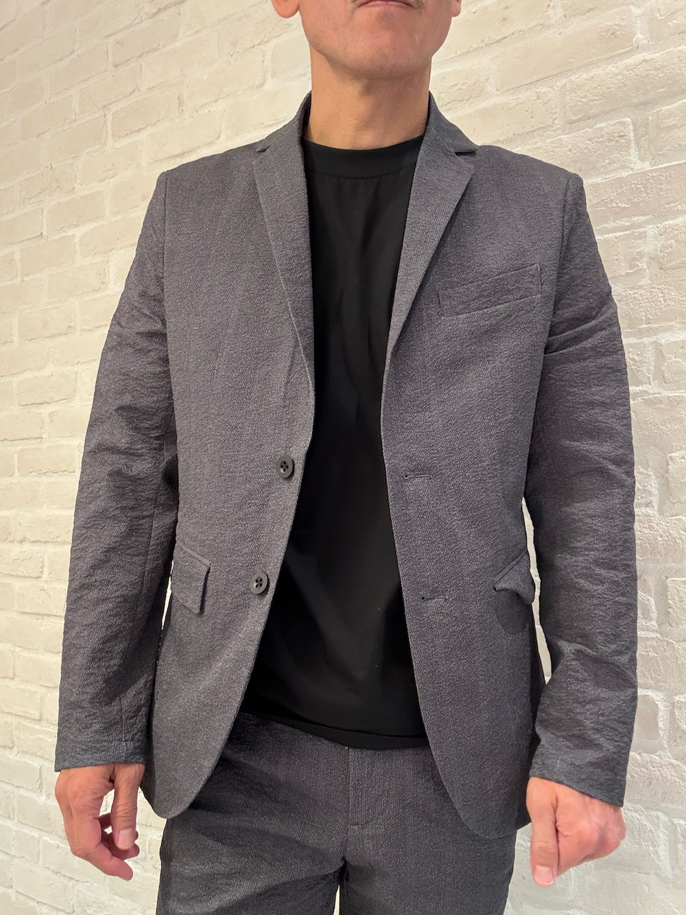 グレー系のセットアップ、グレー系のテーラードジャケット、ブラック系のTシャツ/カットソーを着用したメンズの夏コーディネートの2枚目の写真