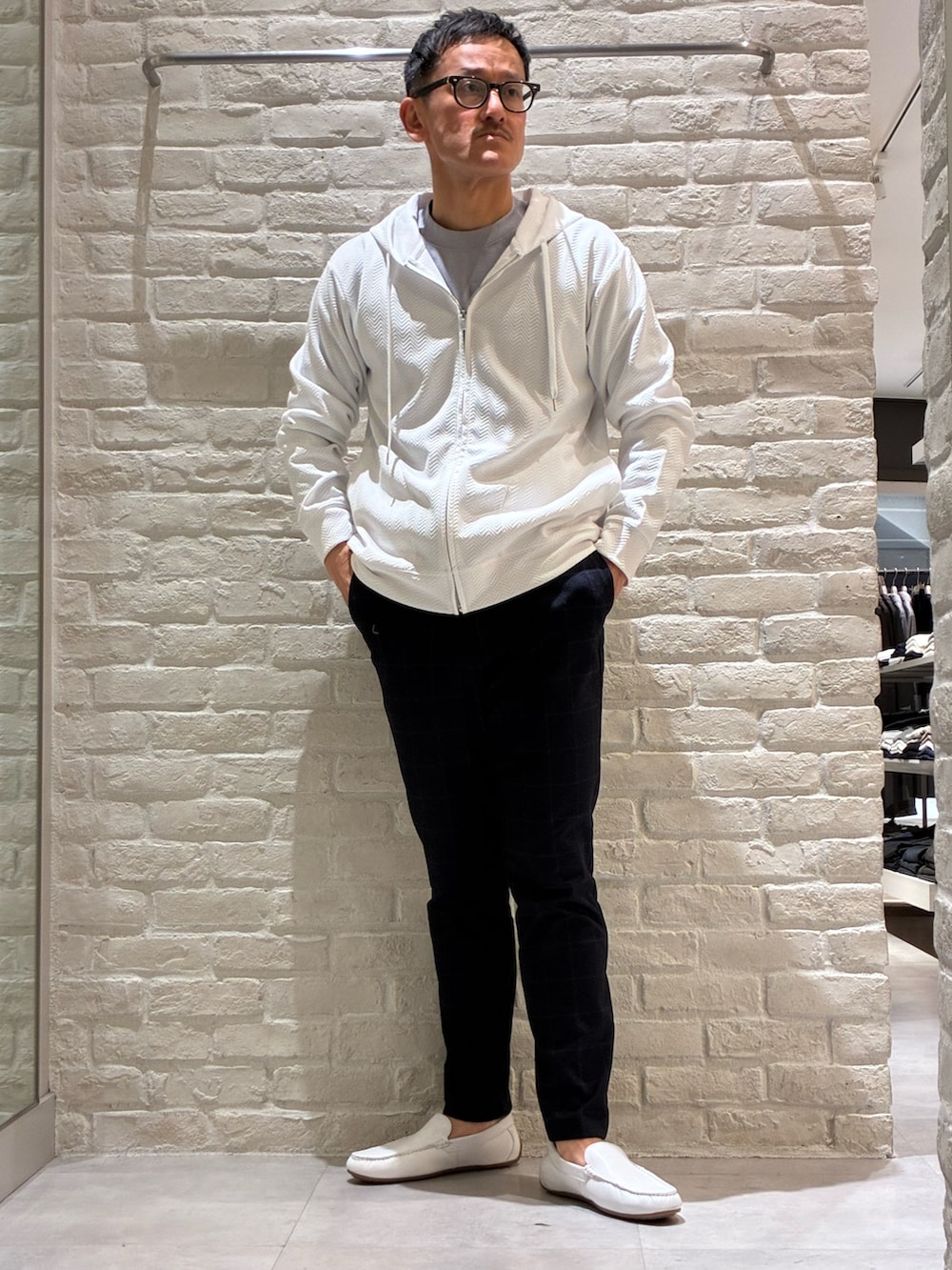 ホワイト系のパーカー、ブルー系のTシャツ/カットソー、ブルー系のスラックスを着用したメンズの春コーディネートの2枚目の写真