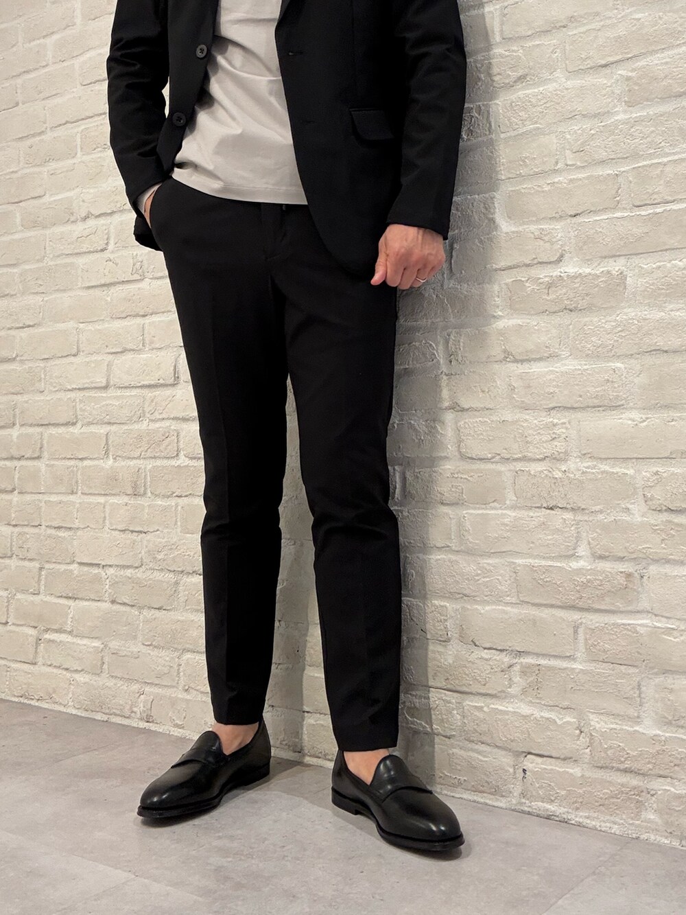 ベージュ系のTシャツ/カットソー、ブラック系のテーラードジャケット、ブラック系のセットアップを着用したメンズの秋コーディネートの5枚目の写真