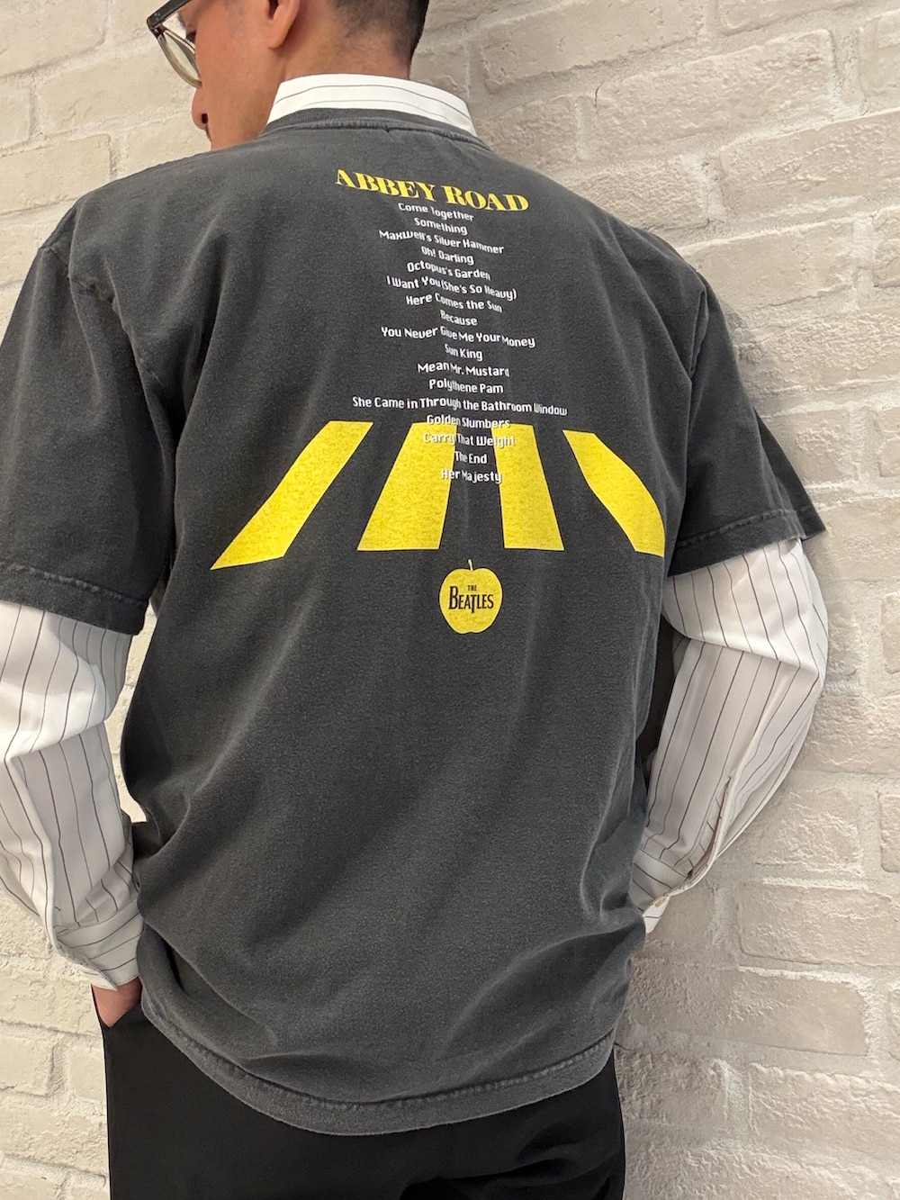 ブラック系のTシャツ/カットソー、ホワイト系のシャツ/ブラウス、ブラック系のスラックスを着用したメンズの春コーディネートの3枚目の写真