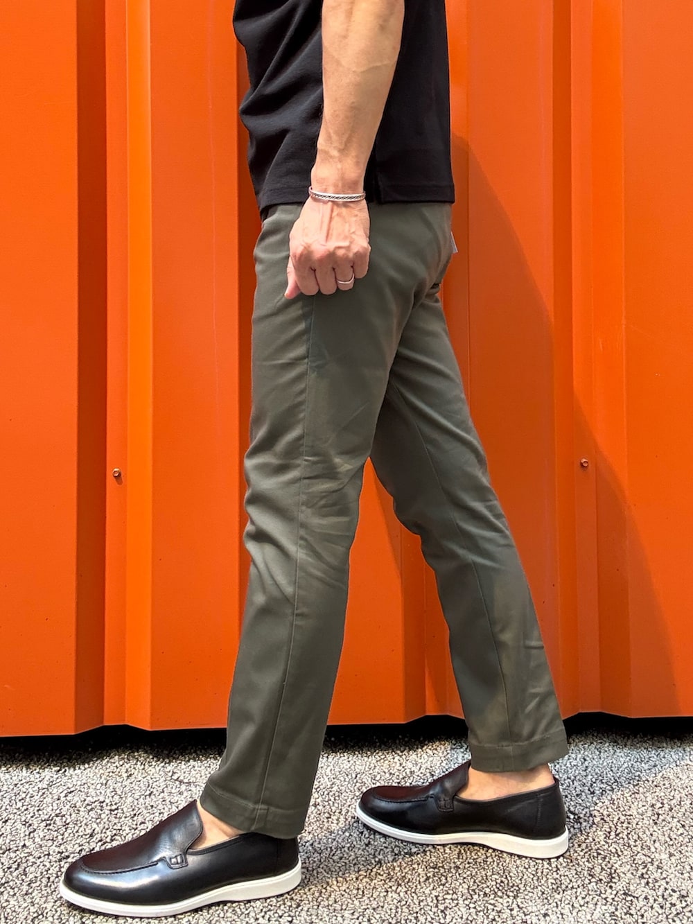 ブラック系のカーディガン/ボレロ、ブラック系のポロシャツ、グリーン系のチノパンツを着用したメンズの秋コーディネートの5枚目の写真