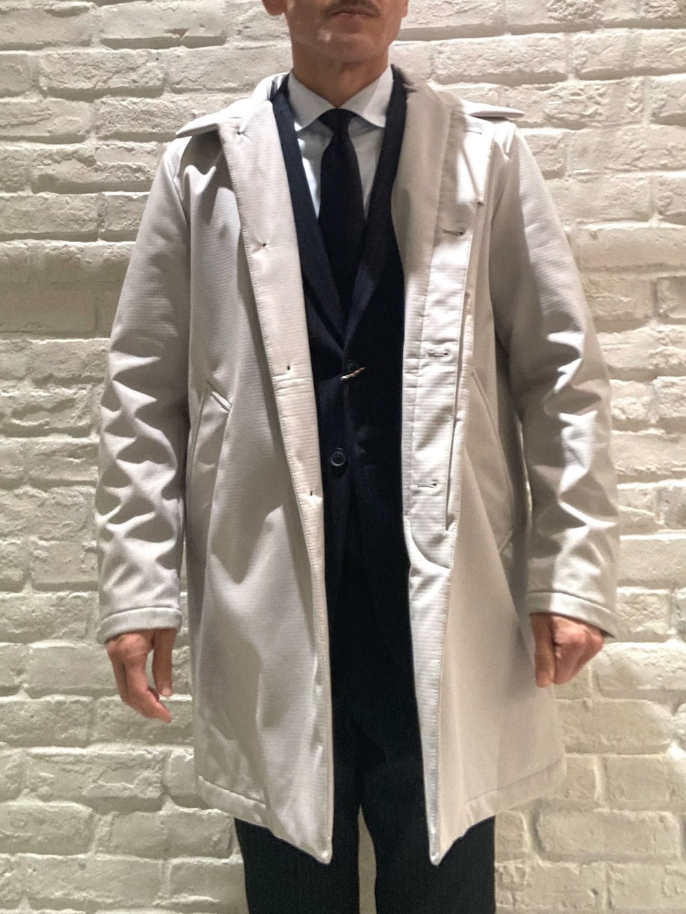 ベージュ系のステンカラーコート、その他のセットアップ、その他のテーラードジャケットを着用したメンズの冬コーディネートの3枚目の写真