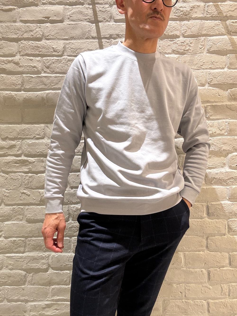 ホワイト系のパーカー、ブルー系のTシャツ/カットソー、ブルー系のスラックスを着用したメンズの春コーディネートの4枚目の写真