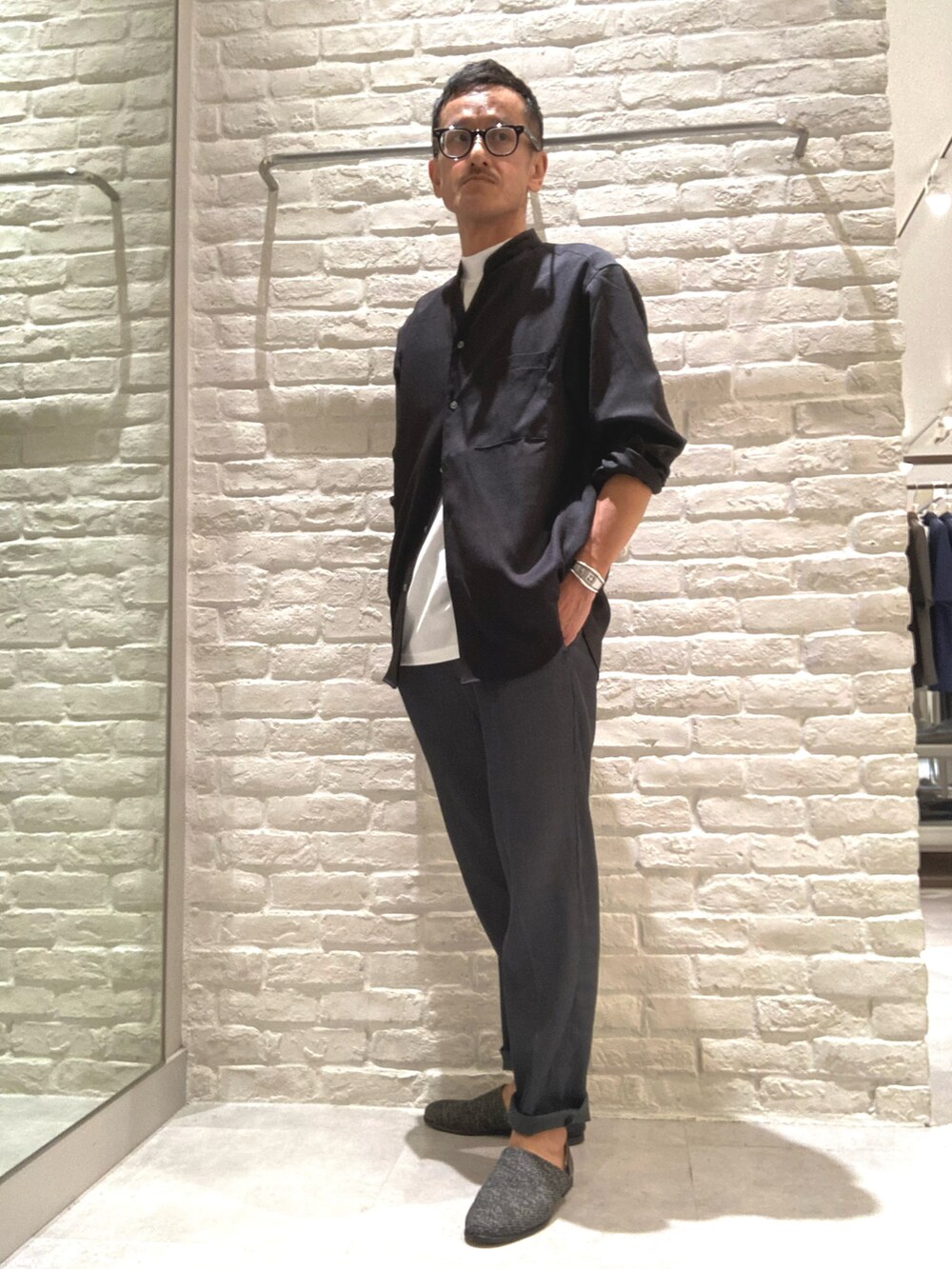 ブラック系のシャツ/ブラウス、ホワイト系のTシャツ/カットソー、グレー系のスラックスを着用したメンズの秋コーディネートの4枚目の写真