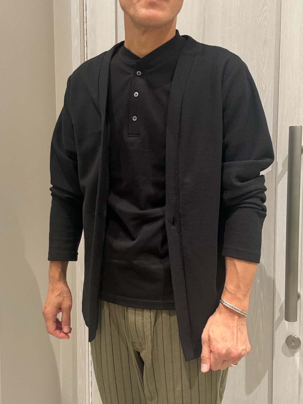ブラック系のカーディガン/ボレロ、ブラック系のTシャツ/カットソー、ブラック系のバックパック/リュックを着用したメンズの夏コーディネートの2枚目の写真