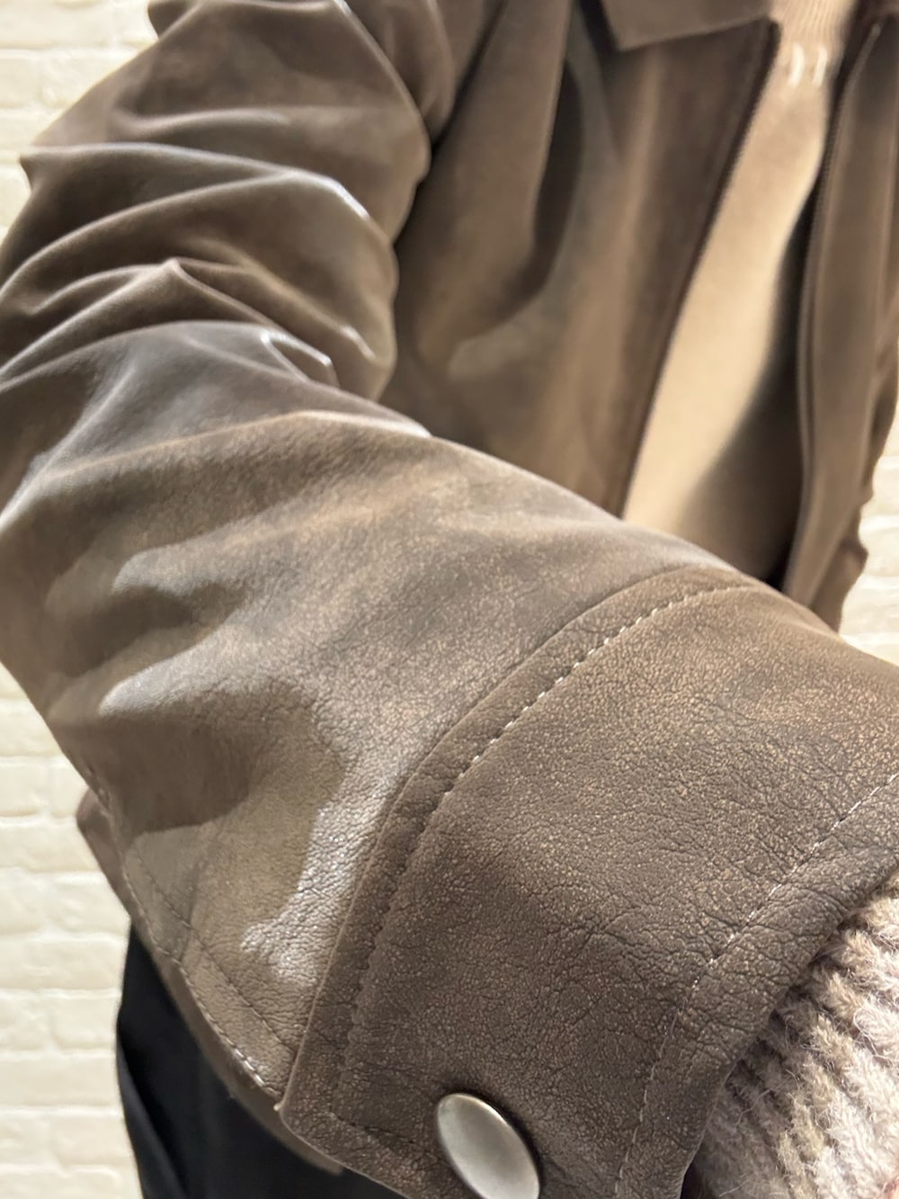 ブラウン系のブルゾン、ベージュ系のニット/セーターを着用したメンズの冬コーディネートの3枚目の写真