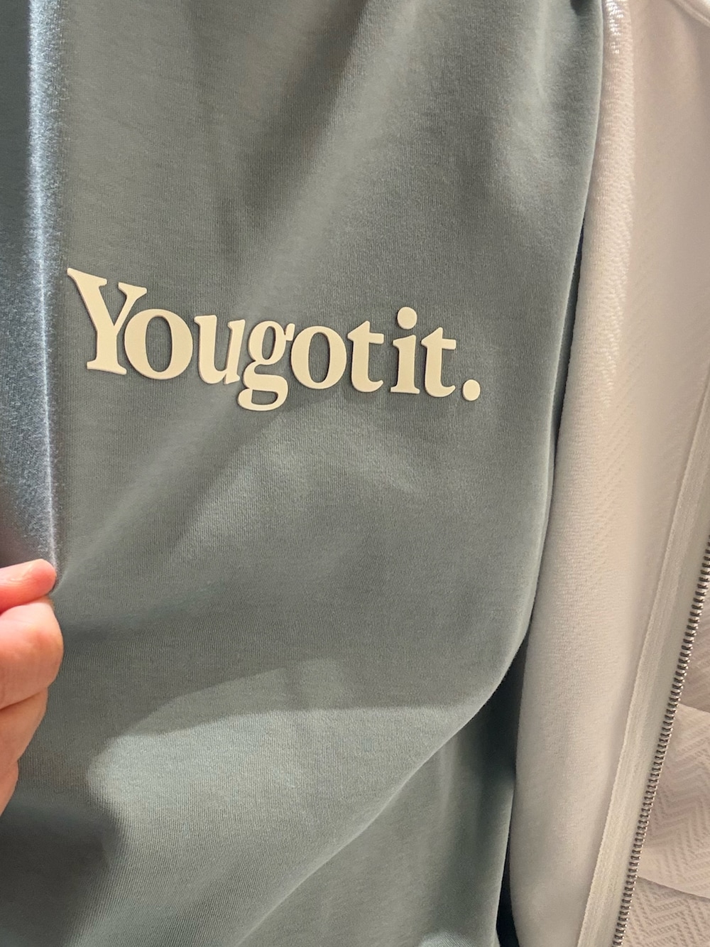 ホワイト系のパーカー、グリーン系のTシャツ/カットソー、ブルー系のスラックスを着用したメンズの春コーディネートの2枚目の写真