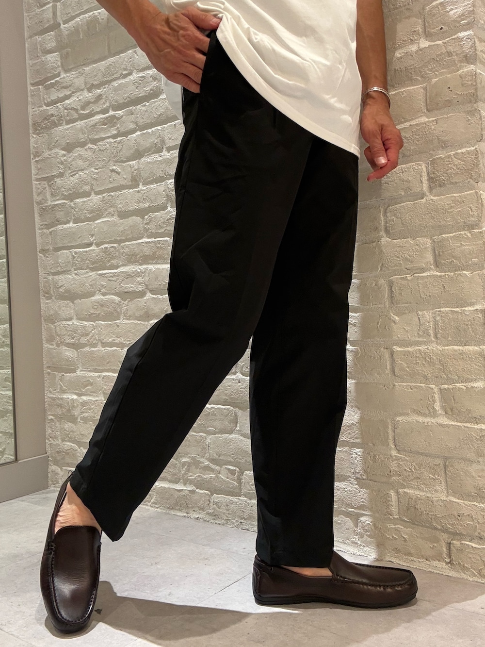 ブラウン系のブルゾン、ホワイト系のTシャツ/カットソー、ブラック系のその他パンツを着用したメンズの夏コーディネートの5枚目の写真