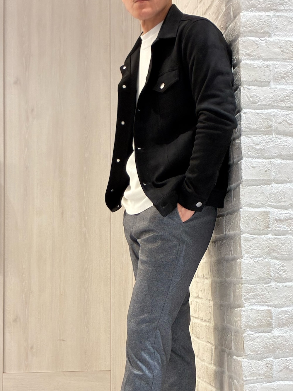 ブラック系のブルゾン、ホワイト系のTシャツ/カットソー、その他のスラックスを着用したメンズの春コーディネートの2枚目の写真