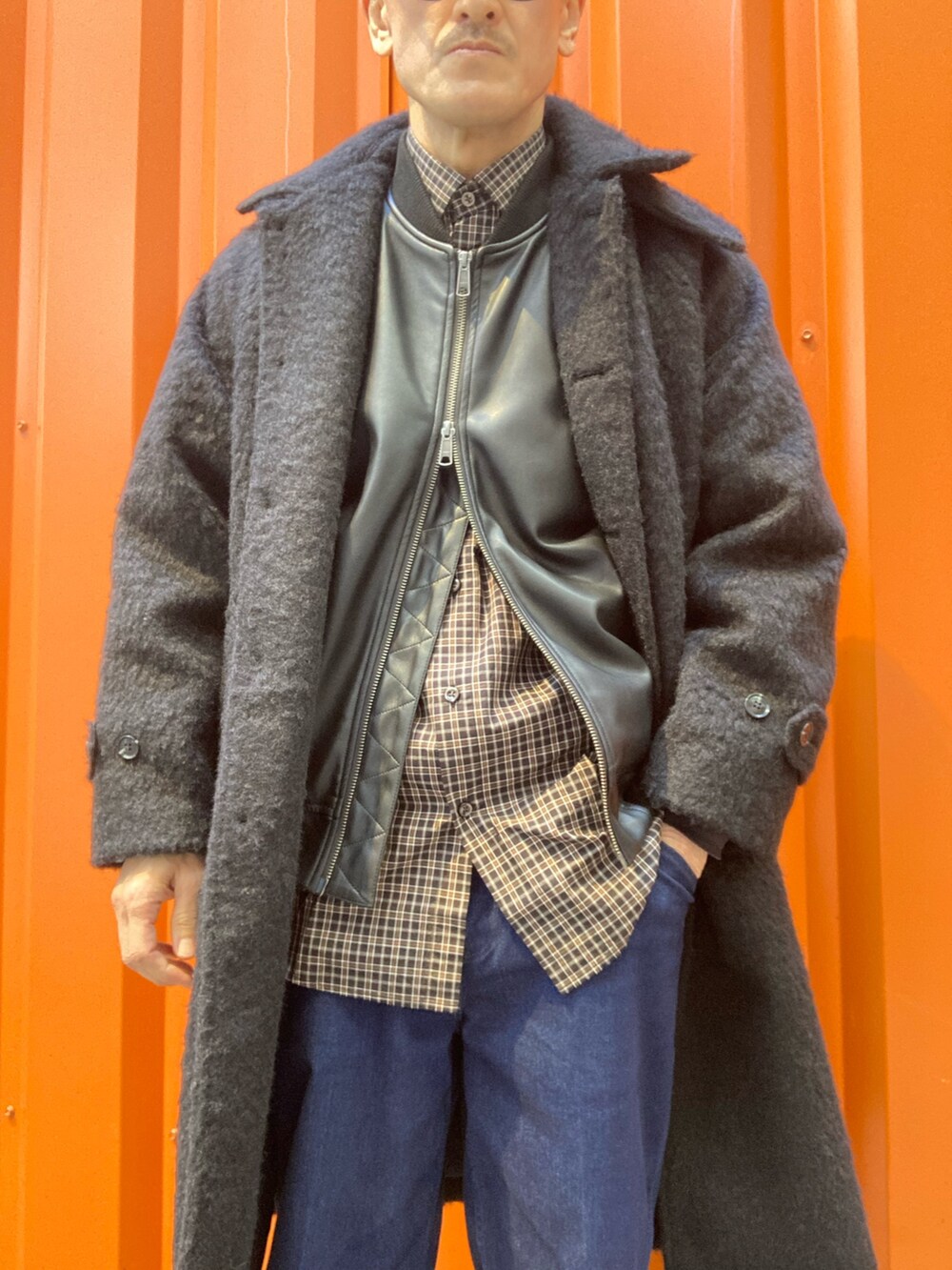 ブラック系のステンカラーコート、ブラック系のライダースジャケット、ブラック系のシャツ/ブラウスを着用したメンズの冬コーディネートの3枚目の写真