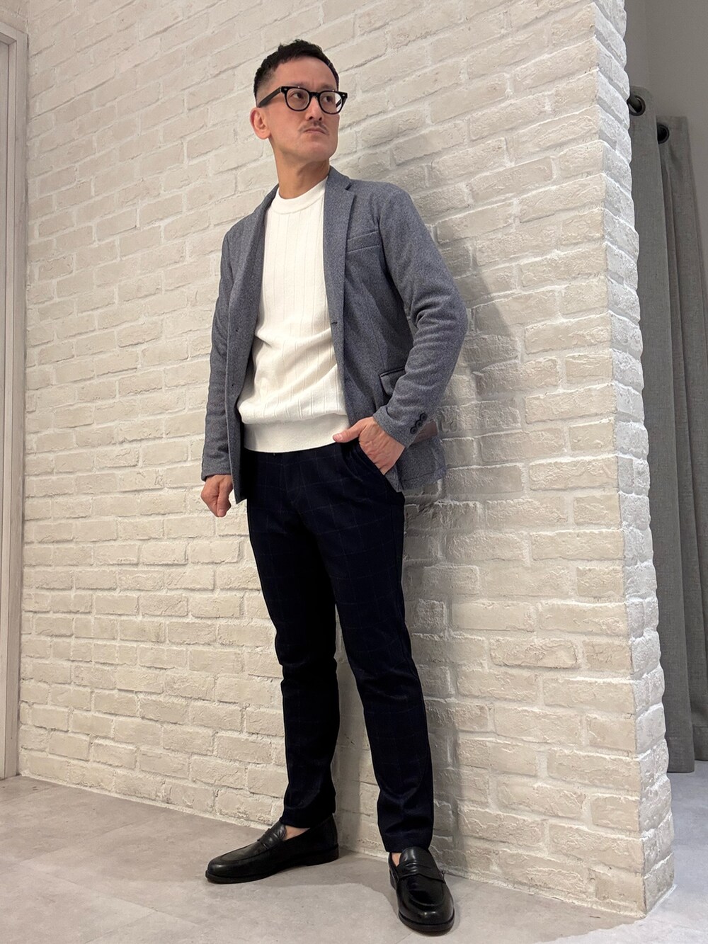 ブルー系のテーラードジャケット、ホワイト系のニット/セーター、ブルー系のスラックスを着用したメンズの冬コーディネートの2枚目の写真