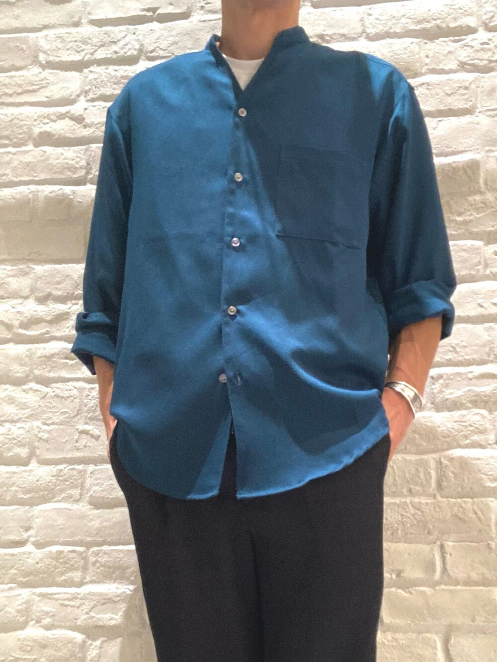 グリーン系のシャツ/ブラウス、ホワイト系のTシャツ/カットソー、ブラック系のスラックスを着用したメンズの秋コーディネートの4枚目の写真