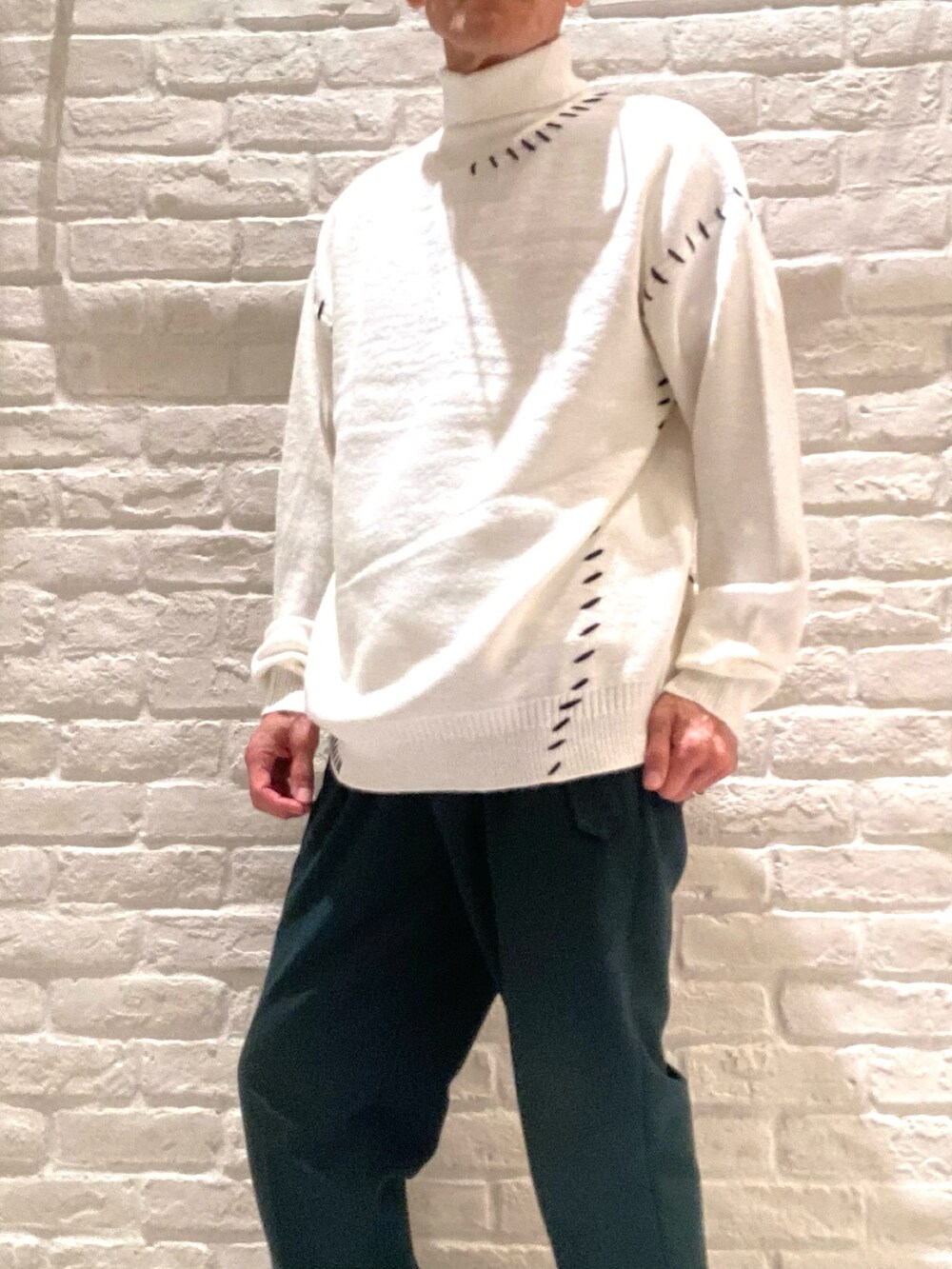 ホワイト系のニット/セーター、グリーン系のその他パンツを着用したメンズの秋コーディネートの3枚目の写真