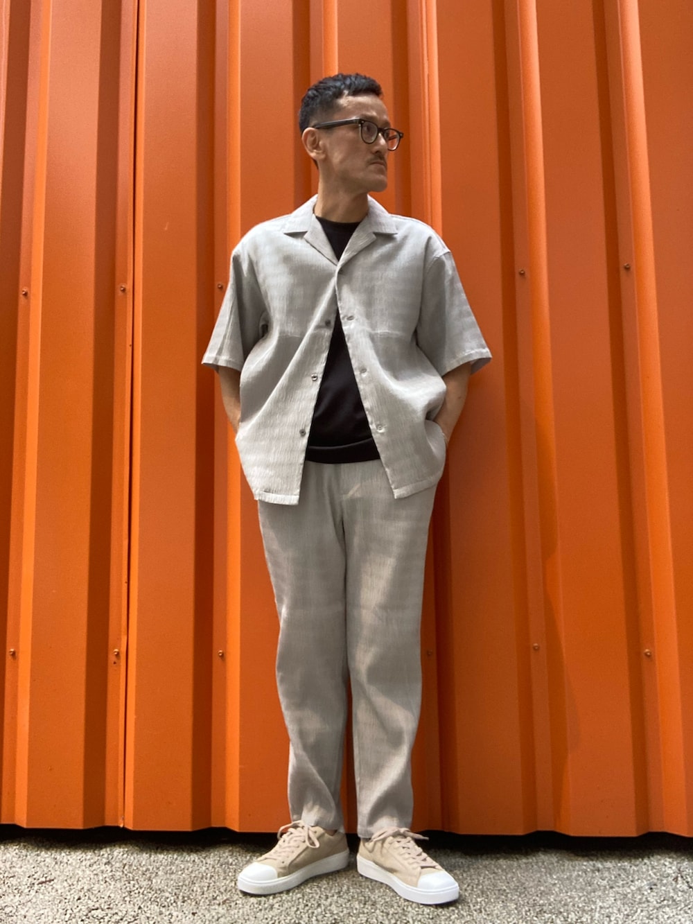 ベージュ系のシャツ/ブラウス、ブラック系のTシャツ/カットソー、ベージュ系のスラックスを着用したメンズの春コーディネートの3枚目の写真