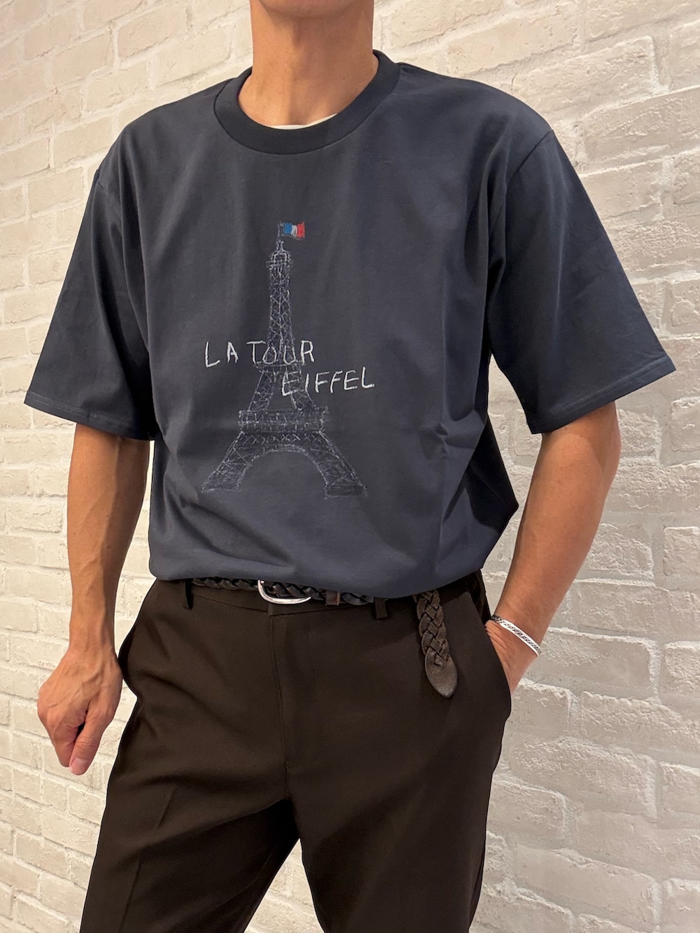 グリーン系のシャツ/ブラウス、ブラック系のTシャツ/カットソー、ブラウン系のスラックスを着用したメンズの夏コーディネートの4枚目の写真