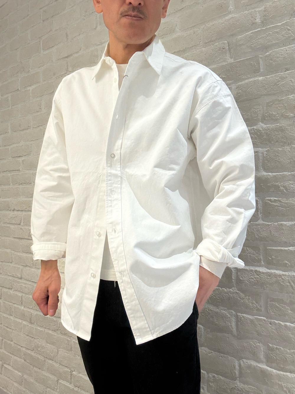 ホワイト系のシャツ/ブラウス、ブラック系のデニムパンツを着用したメンズの春コーディネートの2枚目の写真