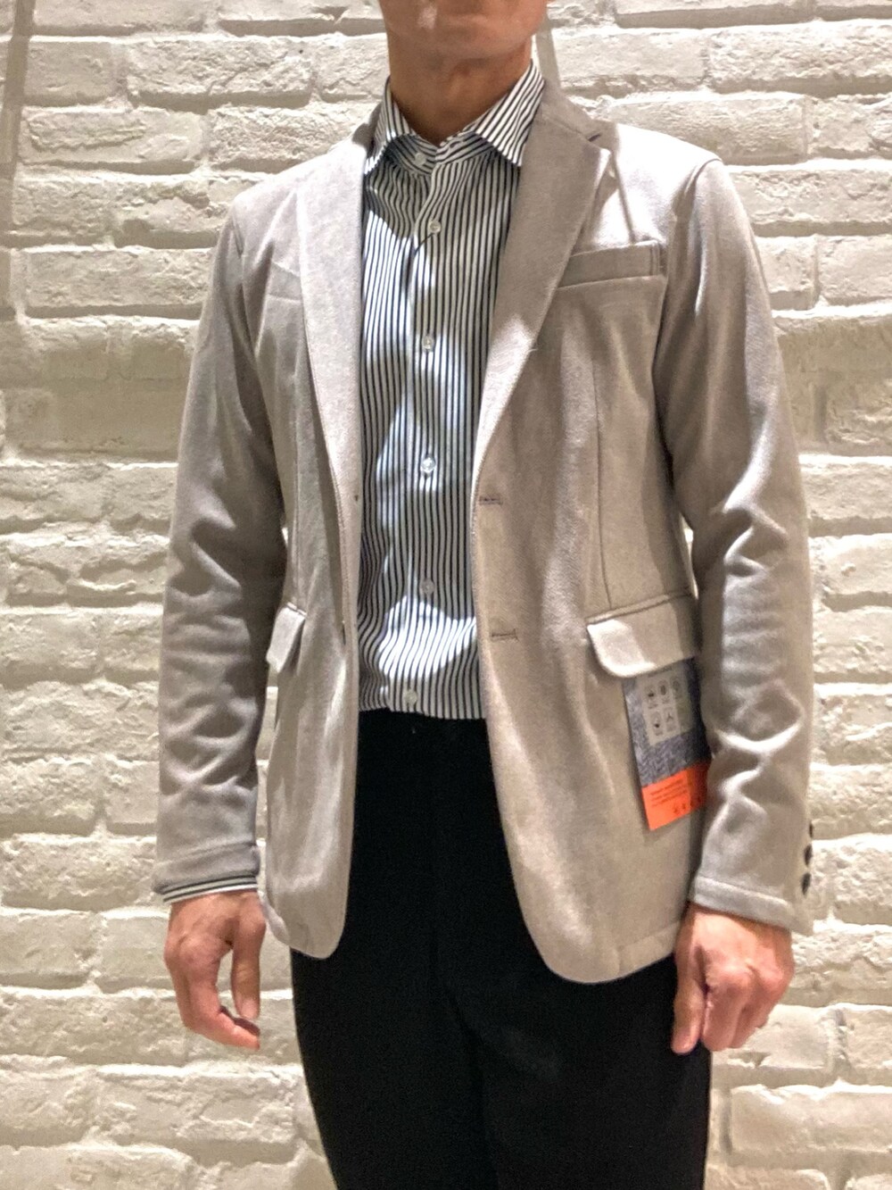 ベージュ系のテーラードジャケット、ブラック系のスラックス、ブラック系のシャツ/ブラウスを着用したメンズの冬コーディネートの3枚目の写真