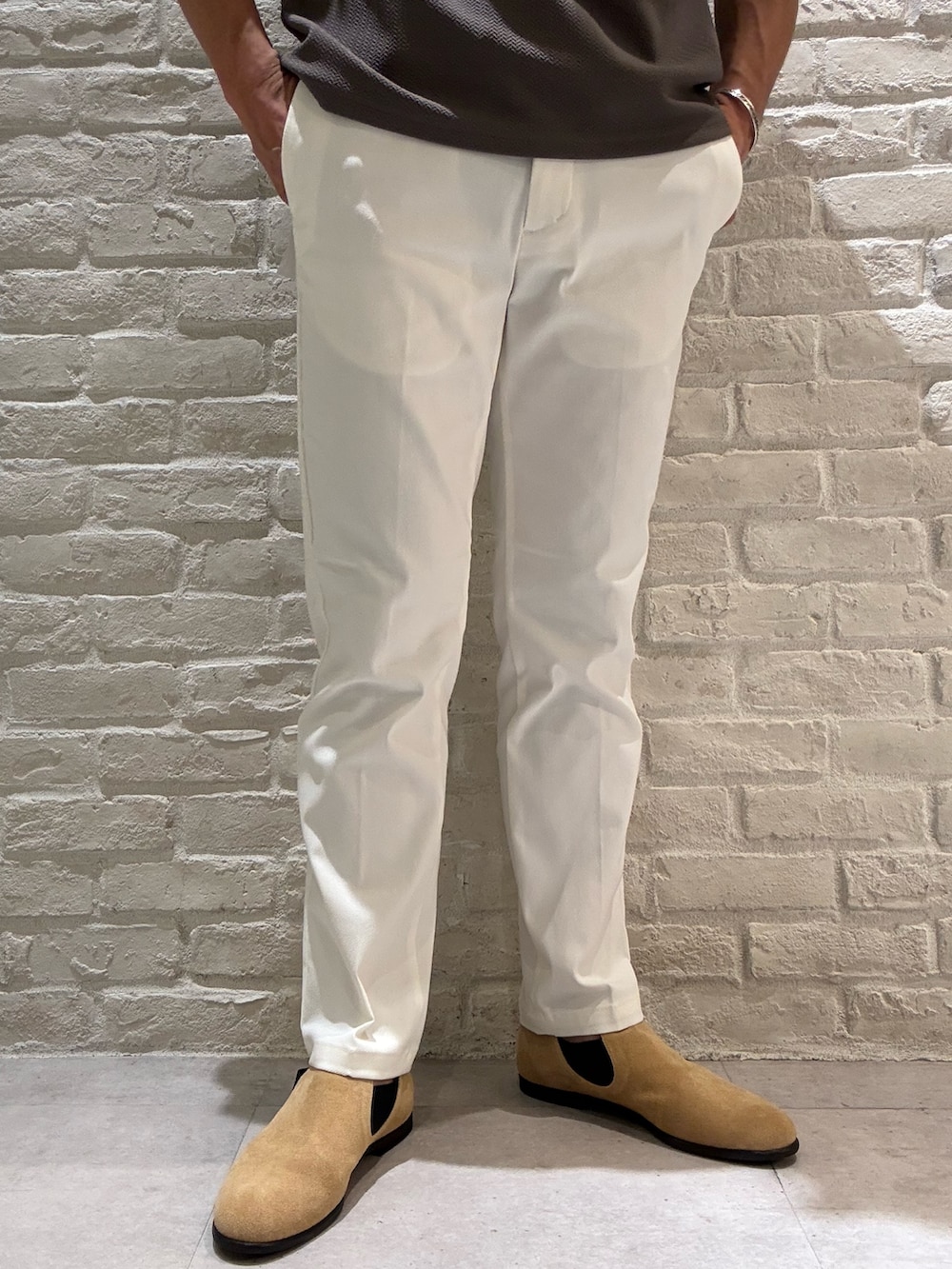 ブラウン系のカーディガン/ボレロ、ブラウン系のTシャツ/カットソー、ホワイト系のスラックスを着用したメンズの秋コーディネートの4枚目の写真