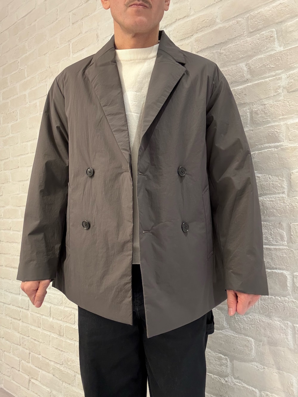 ブラウン系のブルゾン、ホワイト系のニット/セーターを着用したメンズの冬コーディネートの3枚目の写真