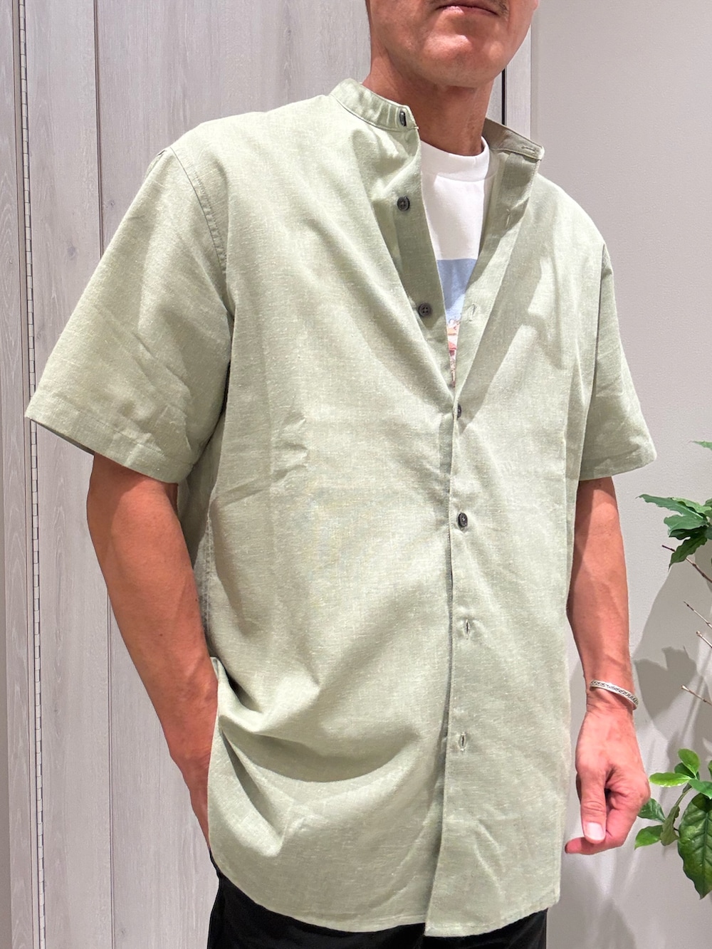 グリーン系のシャツ/ブラウス、その他のTシャツ/カットソー、ブルー系のスラックスを着用したメンズの夏コーディネートの5枚目の写真