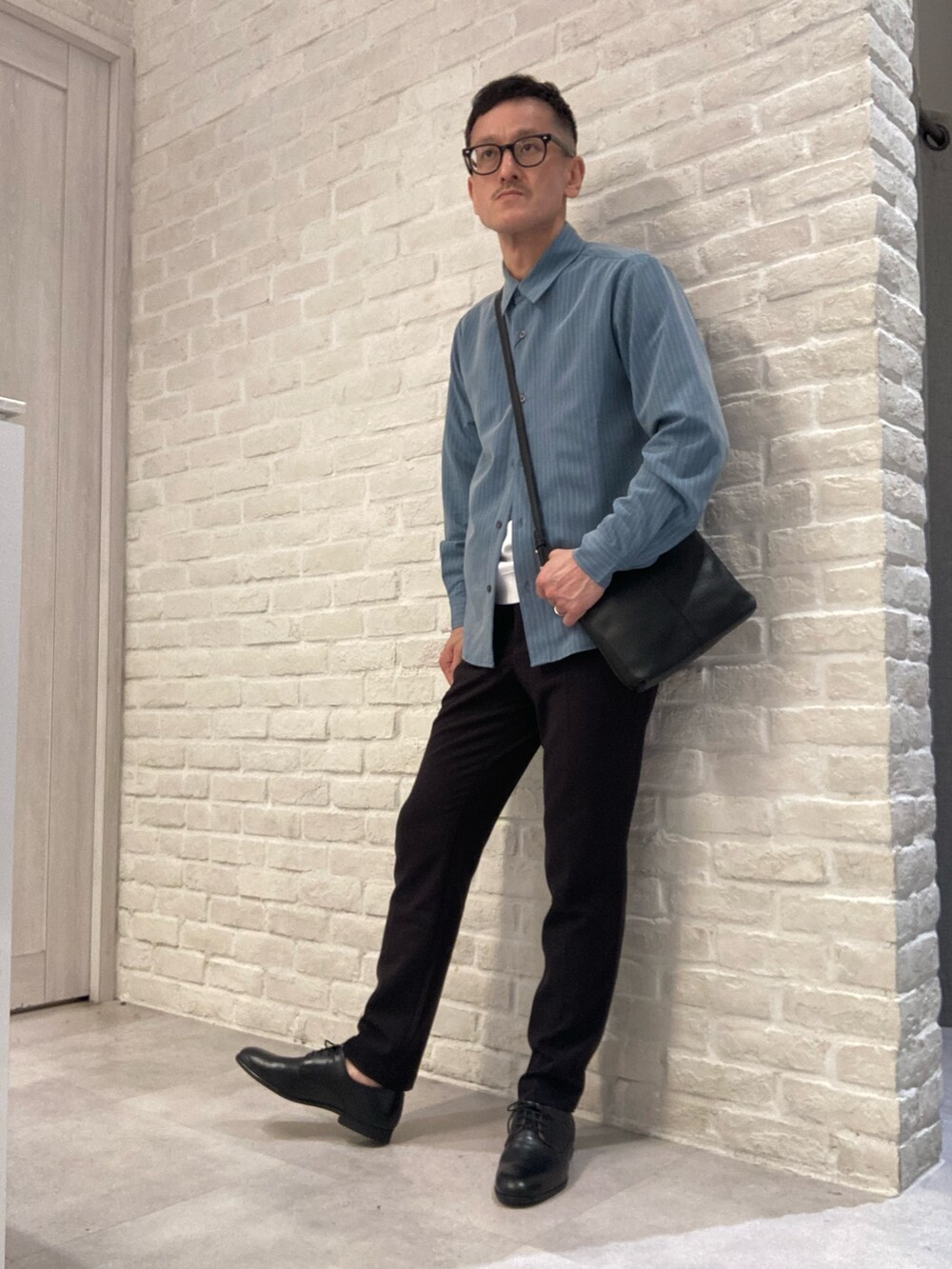 グリーン系のシャツ/ブラウス、ホワイト系のTシャツ/カットソー、ブラック系のスラックスを着用したメンズの春コーディネートの4枚目の写真
