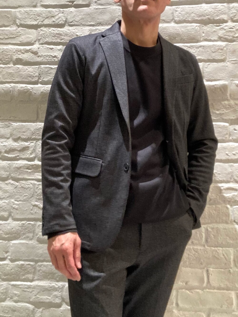 ブラック系のセットアップ、ブラック系のテーラードジャケット、ブラック系のTシャツ/カットソーを着用したメンズの冬コーディネートの2枚目の写真