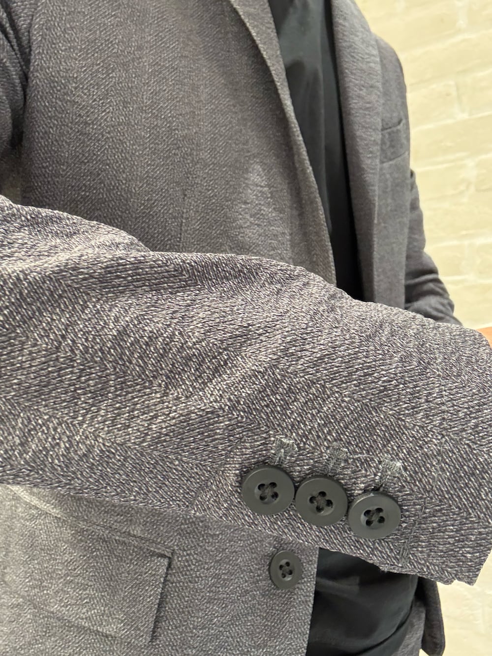 グレー系のセットアップ、グレー系のテーラードジャケット、ブラック系のTシャツ/カットソーを着用したメンズの夏コーディネートの3枚目の写真