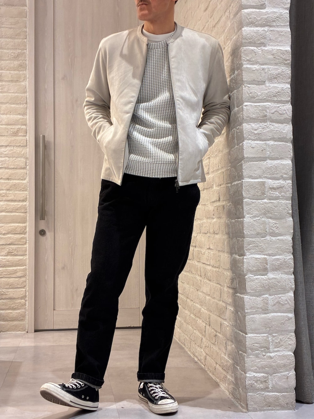 ベージュ系のライダースジャケット、ホワイト系のTシャツ/カットソー、ブラック系のデニムパンツを着用したメンズの春コーディネートの3枚目の写真