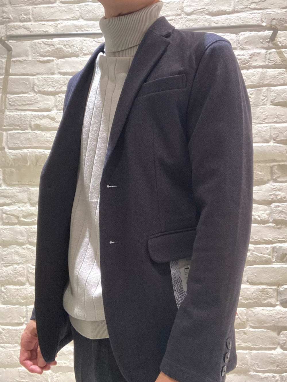 ブルー系のセットアップ、ブルー系のテーラードジャケット、ベージュ系のニット/セーターを着用したメンズの冬コーディネートの3枚目の写真