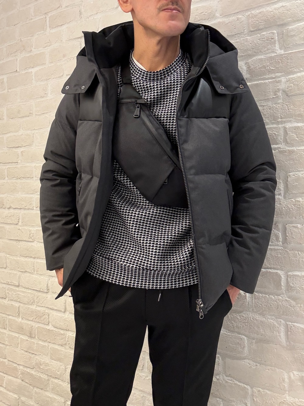 ブラック系のTシャツ/カットソー、グレー系のダウンジャケット/コート、ブラック系のその他パンツを着用したメンズの冬コーディネートの2枚目の写真