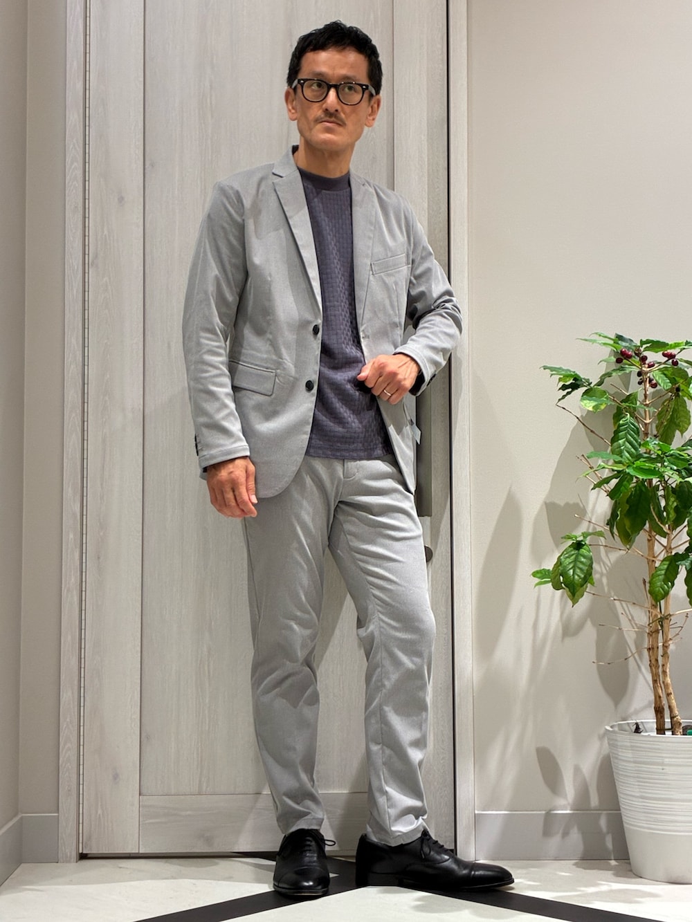 グレー系のセットアップ、グレー系のテーラードジャケット、ブルー系のTシャツ/カットソーを着用したメンズの夏コーディネートの2枚目の写真
