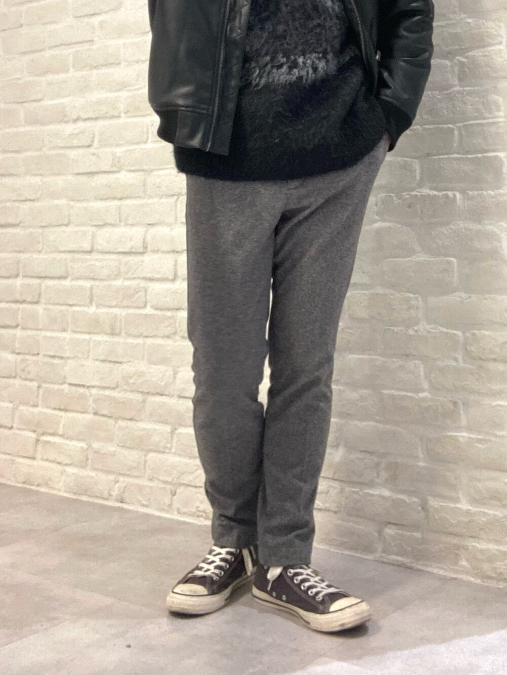 ブラック系のライダースジャケット、ブラック系のニット/セーター、グレー系のスラックスを着用したメンズの冬コーディネートの3枚目の写真