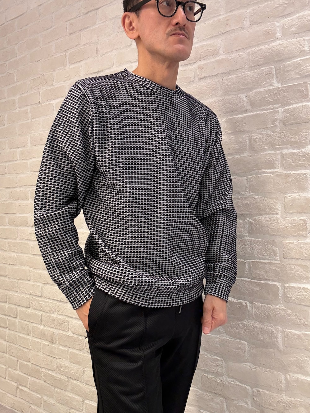 ブラック系のTシャツ/カットソー、グレー系のダウンジャケット/コート、ブラック系のその他パンツを着用したメンズの冬コーディネートの4枚目の写真