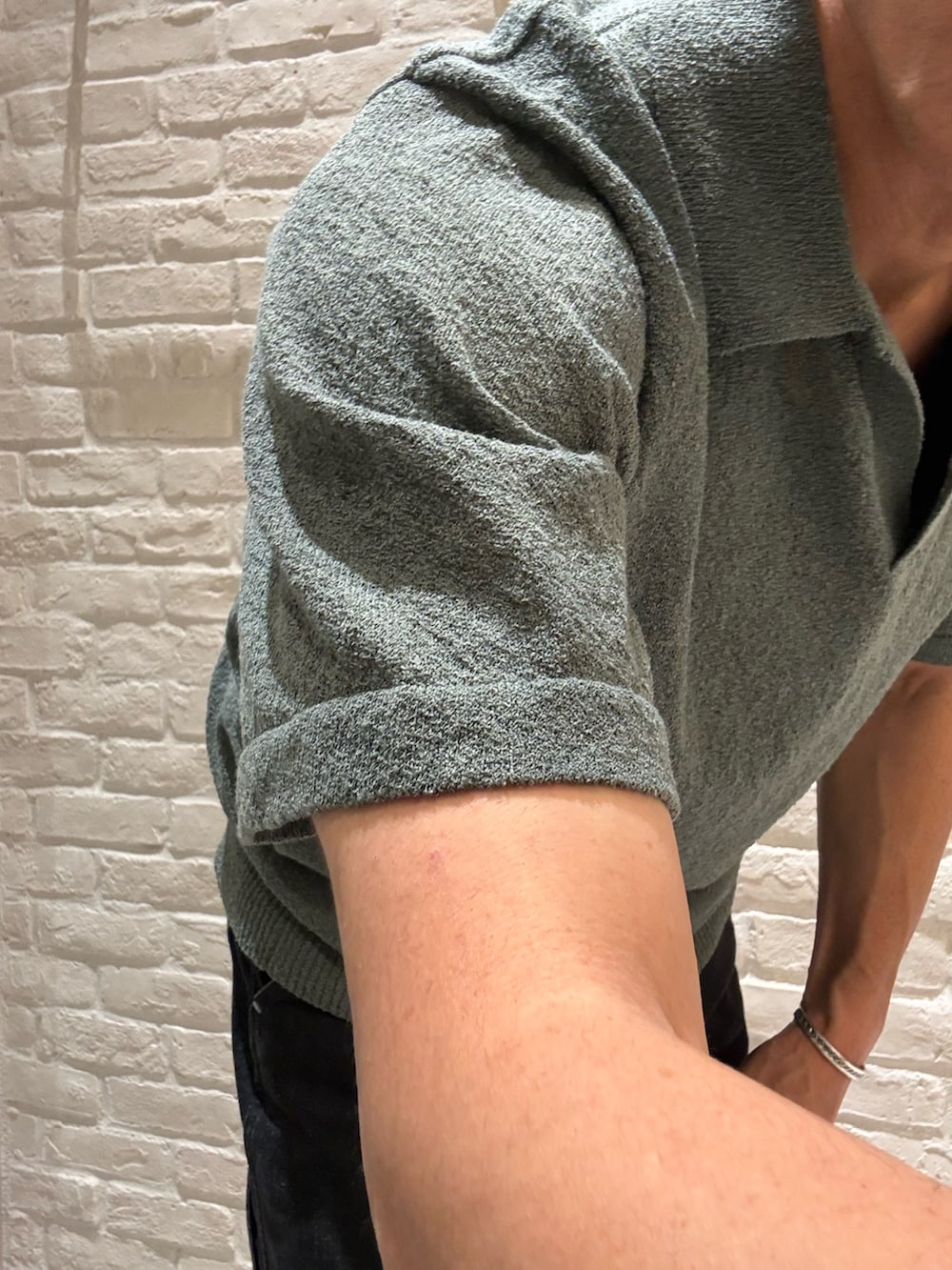 グリーン系のポロシャツ、ブラック系のTシャツ/カットソー、ベージュ系のキャップを着用したメンズの春コーディネートの3枚目の写真