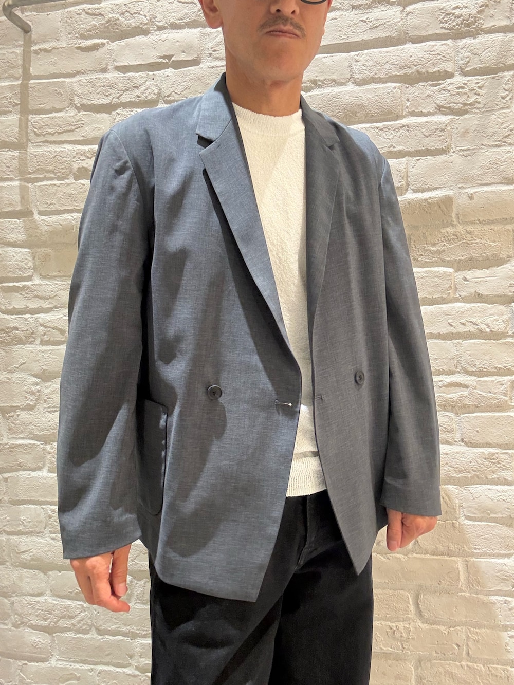 ブルー系のテーラードジャケット、ホワイト系のTシャツ/カットソー、ブラック系のデニムパンツを着用したメンズの秋コーディネートの2枚目の写真