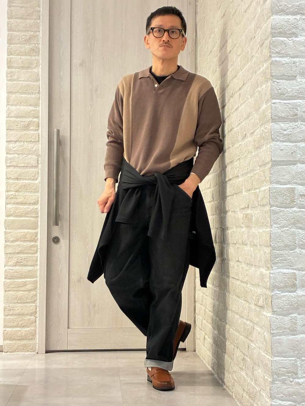 ブラック系のカーディガン/ボレロ、ベージュ系のニット/セーターを着用したメンズの春コーディネートの2枚目の写真