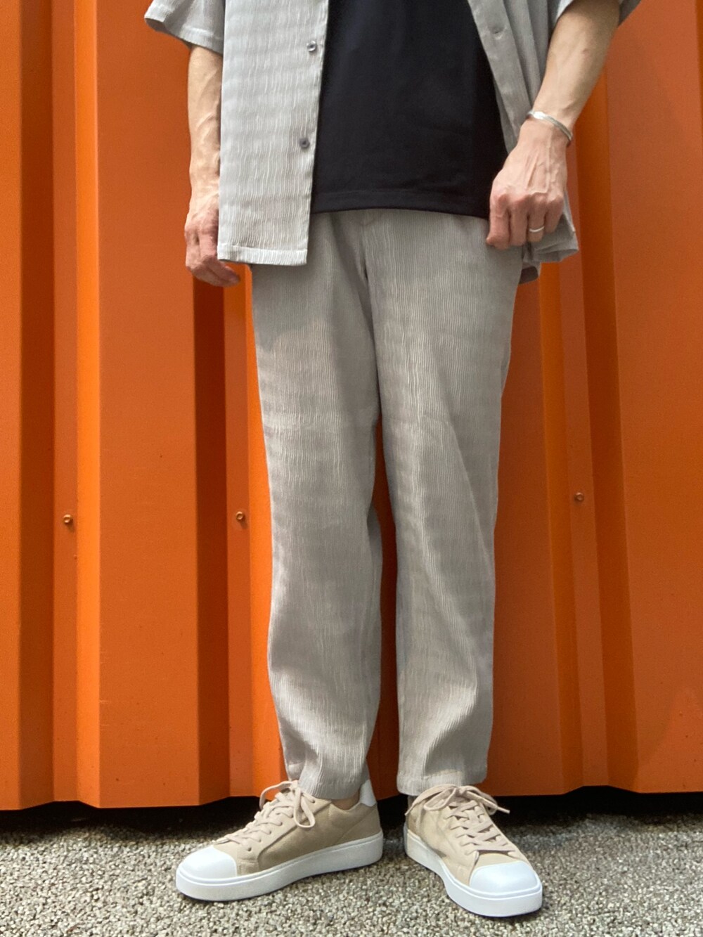 ベージュ系のシャツ/ブラウス、ブラック系のTシャツ/カットソー、ベージュ系のスラックスを着用したメンズの春コーディネートの2枚目の写真