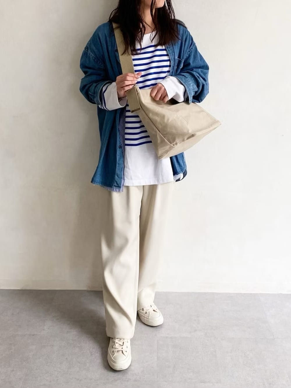 ホワイト系のショルダーバッグ、ブルー系のシャツ/ブラウス、ホワイト系のスラックスを着用したレディースの春コーディネートの3枚目の写真