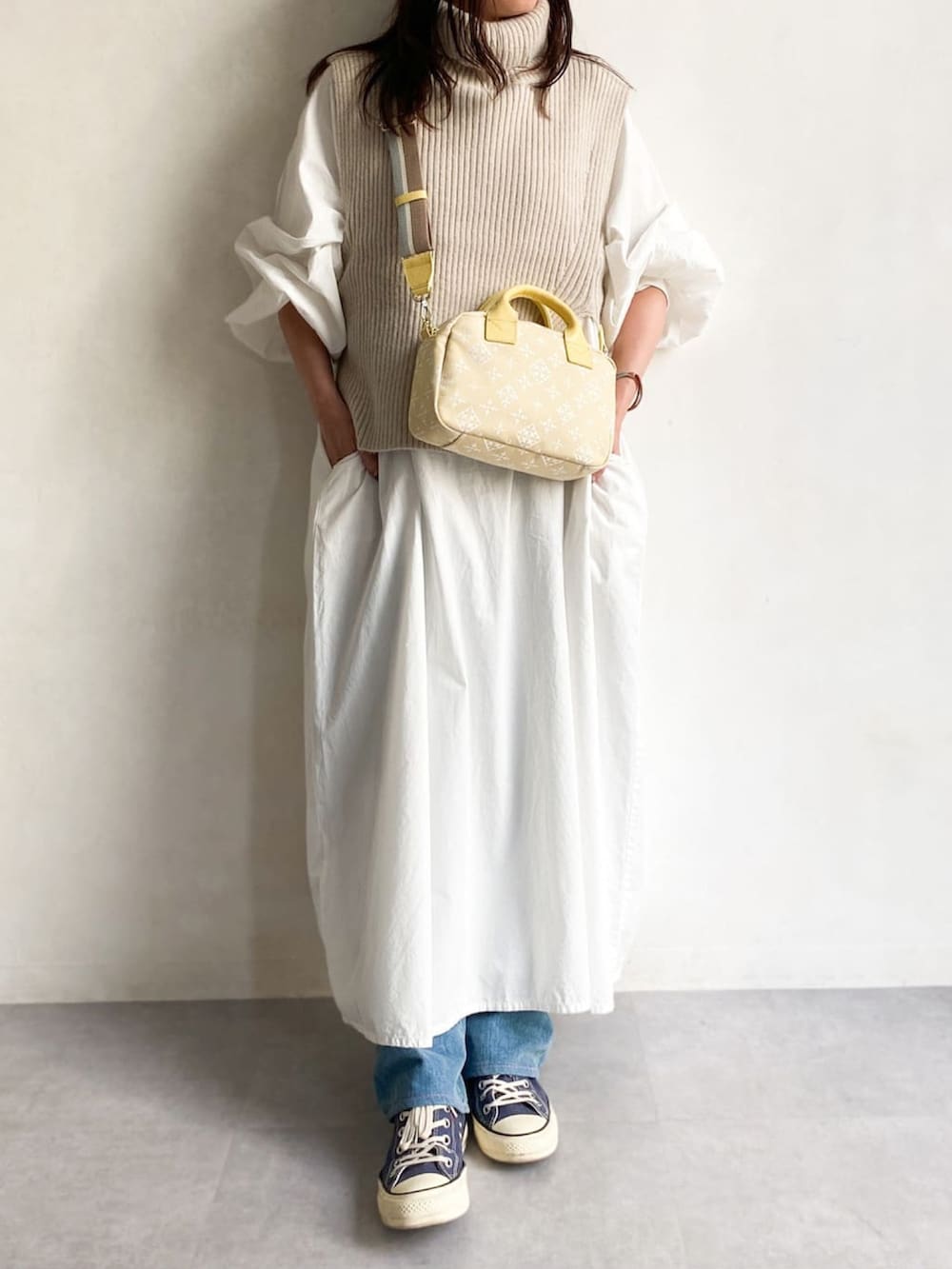 イエロー系のショルダーバッグを着用したレディースの冬コーディネートの3枚目の写真